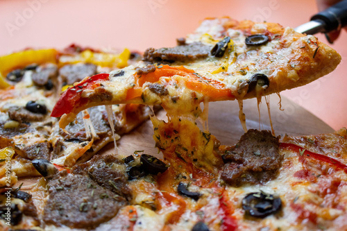 Close up slices of cheese pizza on a spatula photo