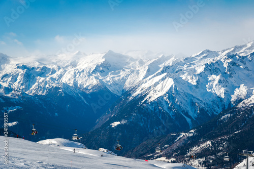 Alpine landscape in the Italian Alps. Snowy mountains and ski lifts
