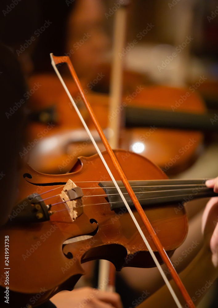 Closeup of the musician's hand is playing a violin in an orchestra. Closeup of the musician's hand is playing a violin in an orchestra.