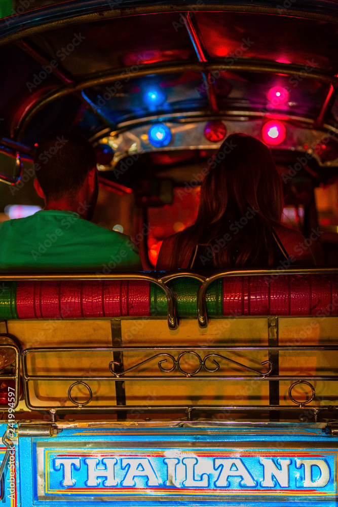 Naklejka premium TukTuk taxi car with passengers at night time in Bangkok, Thailand