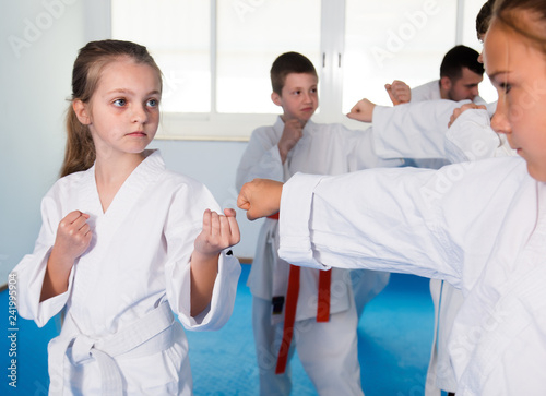 Happy children sparring in pairs in karate class