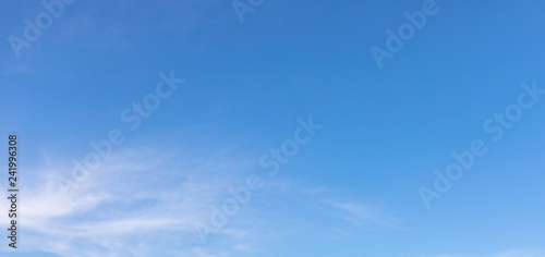 Thin white clouds are floating in the clear blue sky