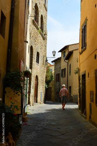 Narrow street in italian old town with yellow buildings