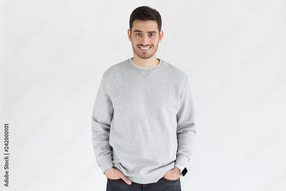 Daylight portrait of young smiling handsome man isolated on gray background Daylight portrait of young smiling handsome man isolated on gray background