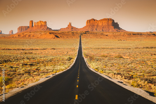 Straight road in Monument Valley at sunset, USA