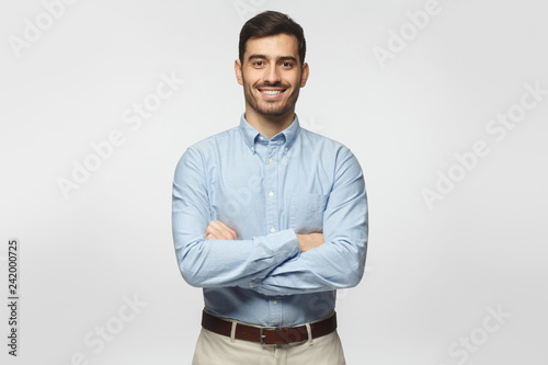 Handsome smiling business man in blue shirt isolated on gray background photo