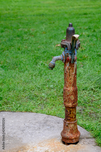 Fotografie A portrait of a vertical and old fashioned rustic water fountain made of iron, w