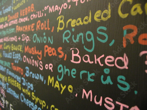 Takeaway menu board written in multiple marker pen colours.