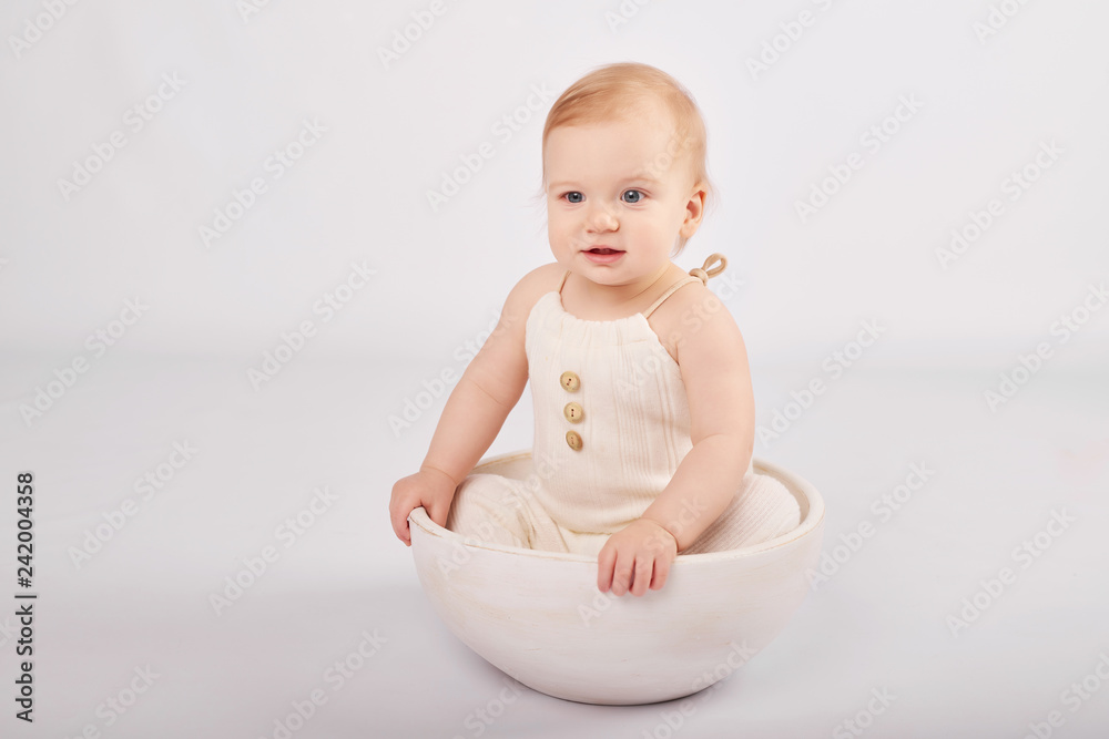 Toddler boy in an Easter bunny costume on a light background with Easter eggs Toddler boy in an Easter bunny costume on a light background with Easter eggs