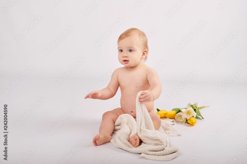 cute toddler boy on a light background with a bouquet of flowers cute toddler boy on a light background with a bouquet of flowers
