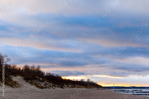 wide beach by the sea under a beautiful cloudy sky at sunset