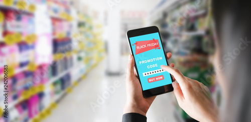 Women holding the smartphone to enter the code to get a discount from Black friday. The concept of providing marketing services on the internet for easy access to information.