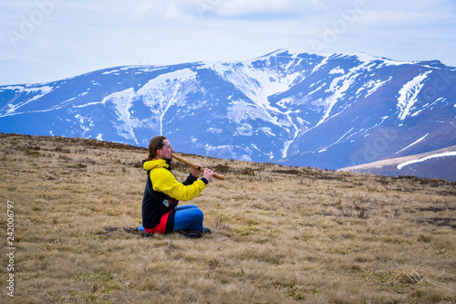 a musician plays the shakuhachi flute in the mountains