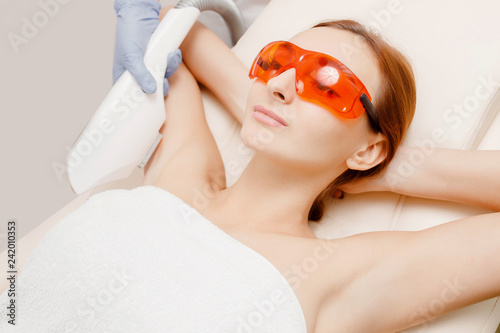 Tablou pe pânză Young red-haired woman demonstrates smoothness her armpits