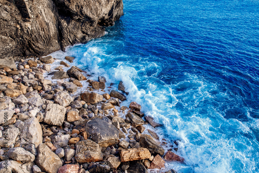 Top view blue ocean water, waves breaking stones. Concept freedom, strength.