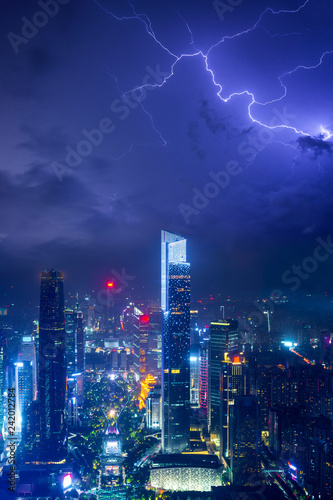 Night cityscape of guangzhou urban skyscrapers at storm with lightning bolts in night purple blue sky, Guangzhou, China