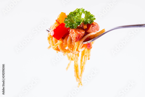 Spaghetti with sauce decorated with parsley on a fork on a white background