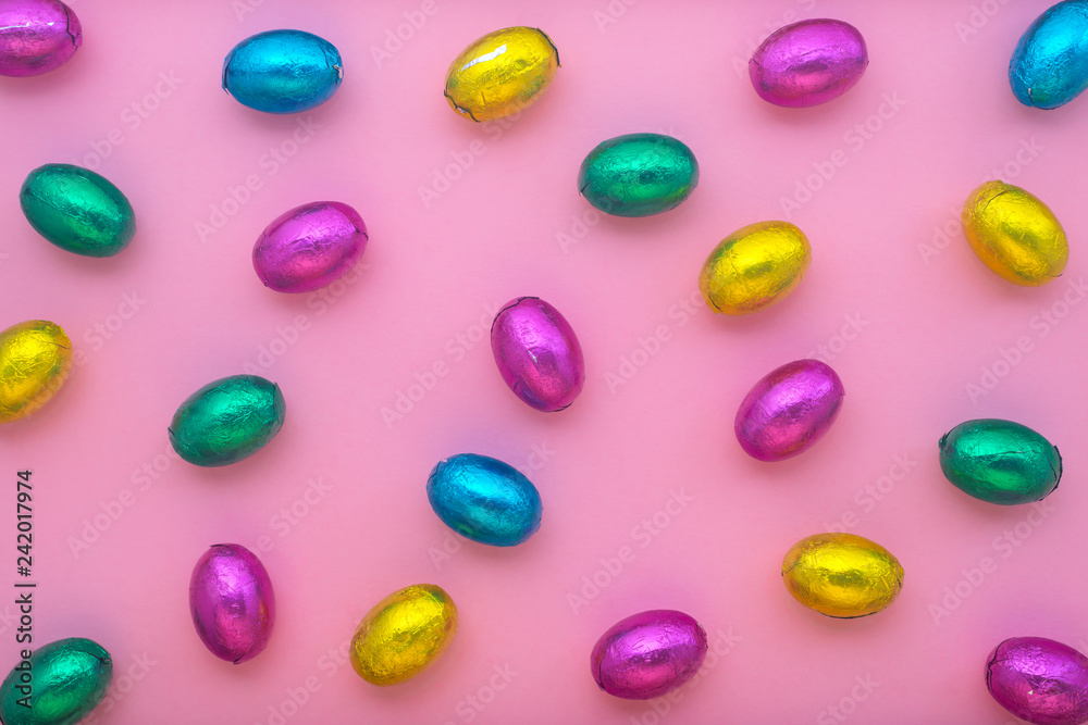 Easter eggs in colorful foil over pink, holiday background Easter eggs in colorful foil over pink, holiday background