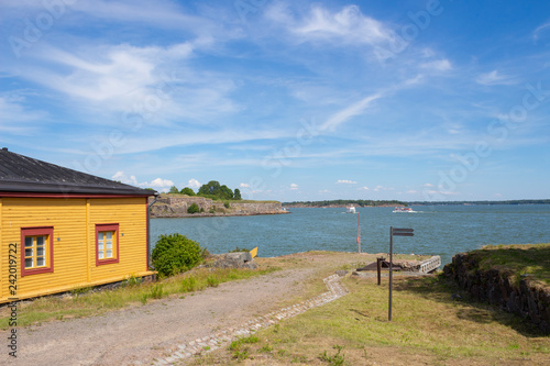 Fototapeta Naklejka Na Ścianę i Meble -  A wooden rural house on the coast of the Gulf of Finland is located on the island of Suomenlinna in Finland on a summer sunny day.