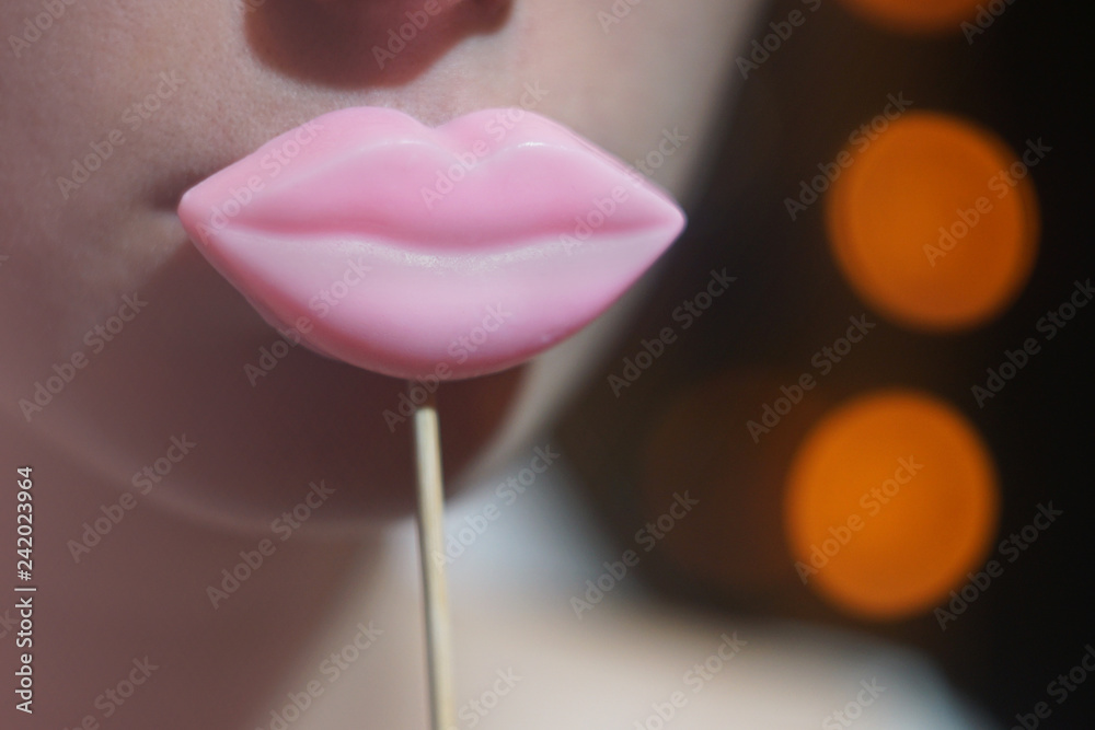 Φωτογραφία Beauty joyful Young Funny fashion model Girl holding big pink lips on a stick smiling, Beauty concept