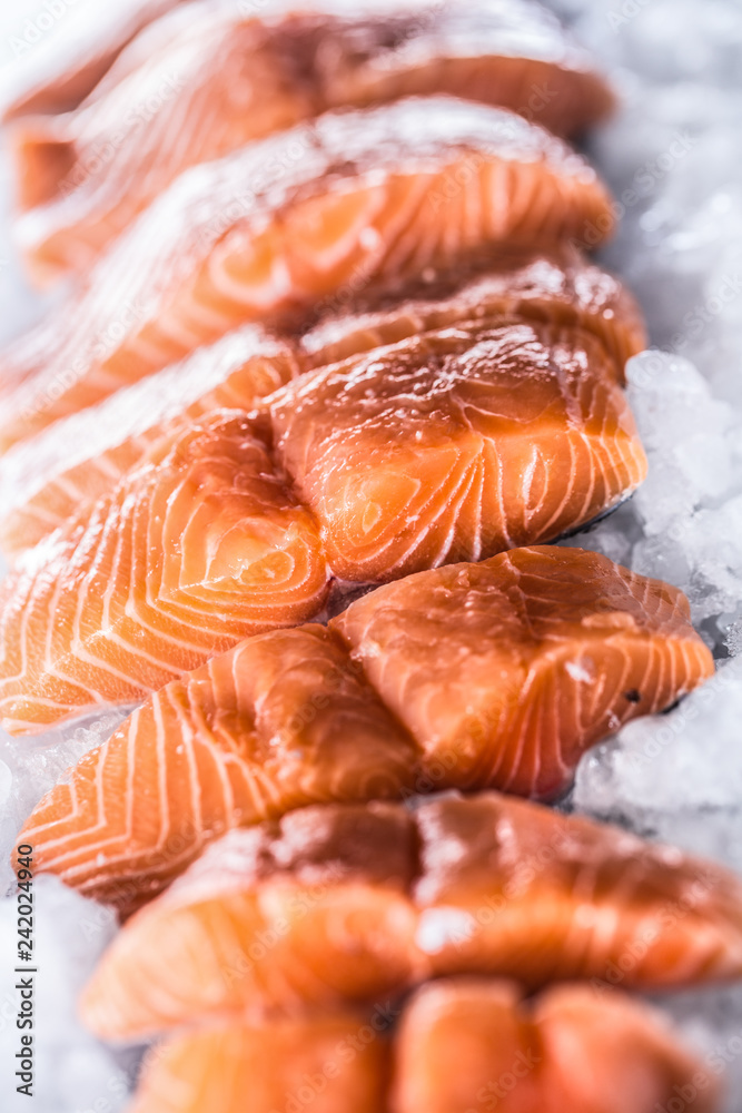 Salmon fillets portioned on ice and empty kitchen board Salmon fillets portioned on ice and empty kitchen board