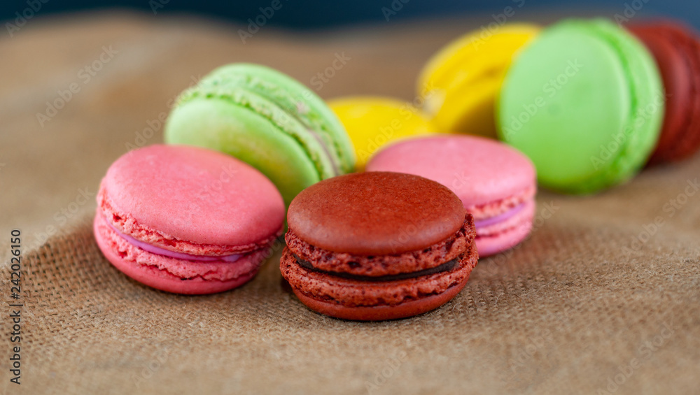 Macarons cakes of different colors on a burlap Macarons cakes of different colors on a burlap