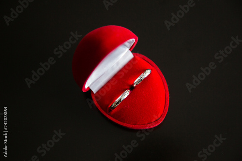 Wedding rings in a red heart-shaped velvet jewelry box