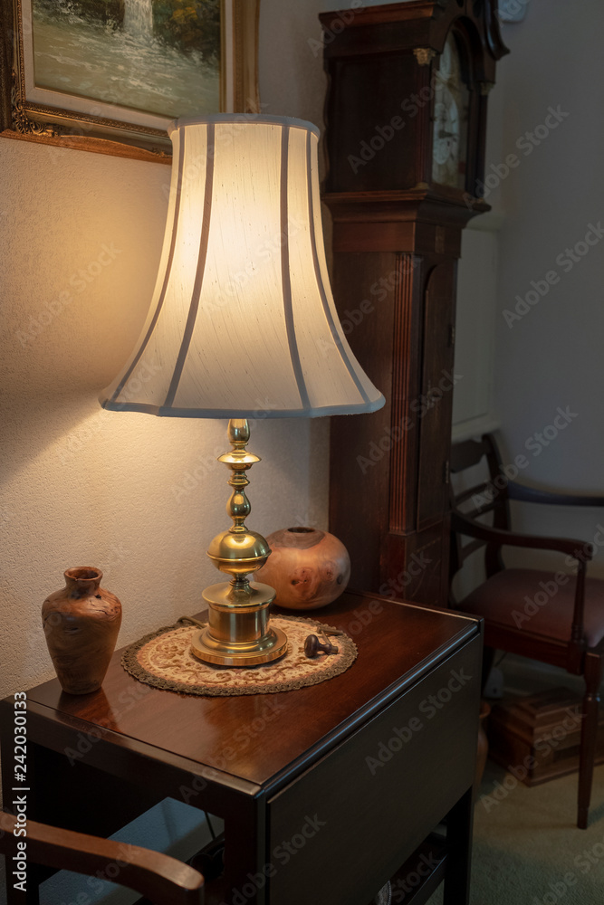 Brass table lamp and turned wood vases on wooen occasioal table in lounge room. Brass table lamp and turned wood vases on wooen occasioal table in lounge room.
