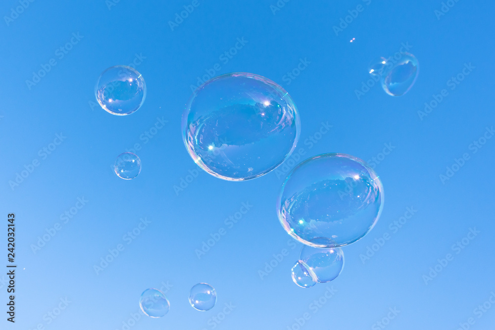 Soap bubble fly on blue sky background.