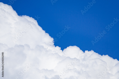 White cumulus fluffy clouds against a blue sky (background)