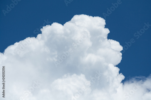 View on a fragment of white cumulus fluffy clouds in  blue sky (background, close up)