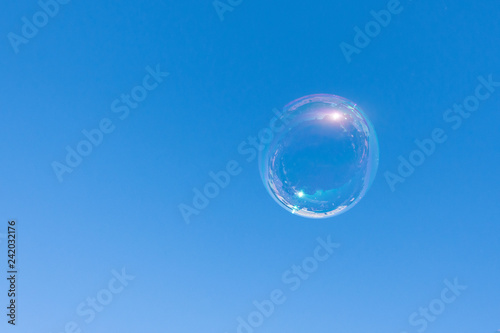 Alone soap bubble fly on blue sky background