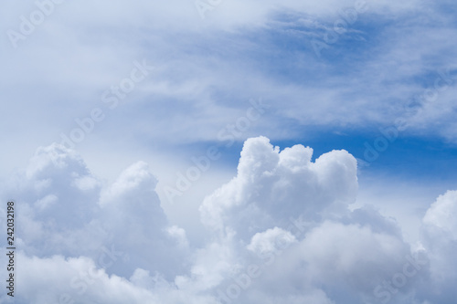 Close up view on a white cumulus fluffy clouds in the blue sky with copy space as background (abstract)