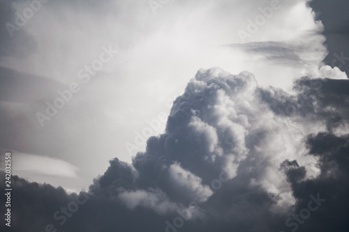 Dramatic view on a dark gray fluffy clouds as background (abstract)