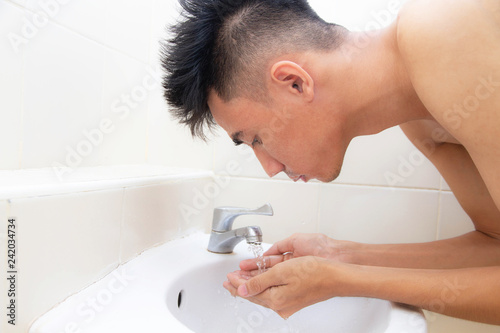 Young man face wash sink bathroom