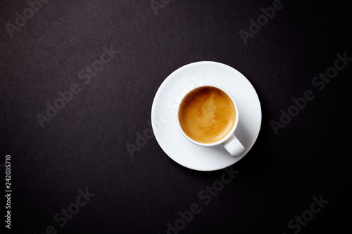 Cup of coffee on black background. Top view. Copy space.
