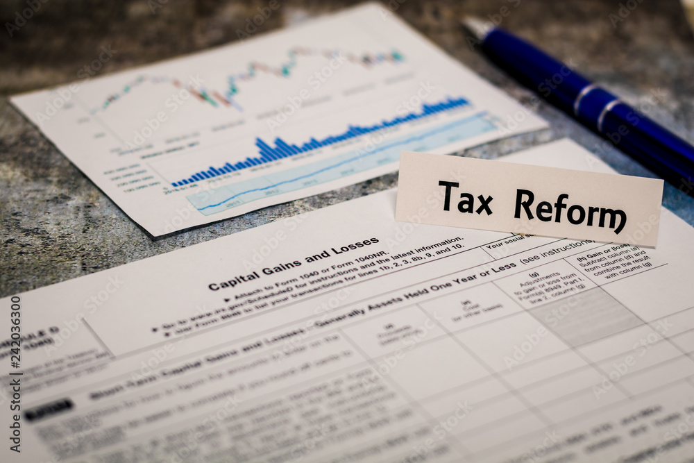 Tax Reform still life business finance concept with laptop, stock chart, shallow DOF Tax Reform still life business finance concept with laptop, stock chart, shallow DOF