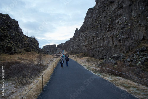 Thingvellir, Iceland - July 19, 2017: Tourists walk through the Almannagja fault line in the mid-atlantic ridge north american plate in Thingvellir National Park. Iceland