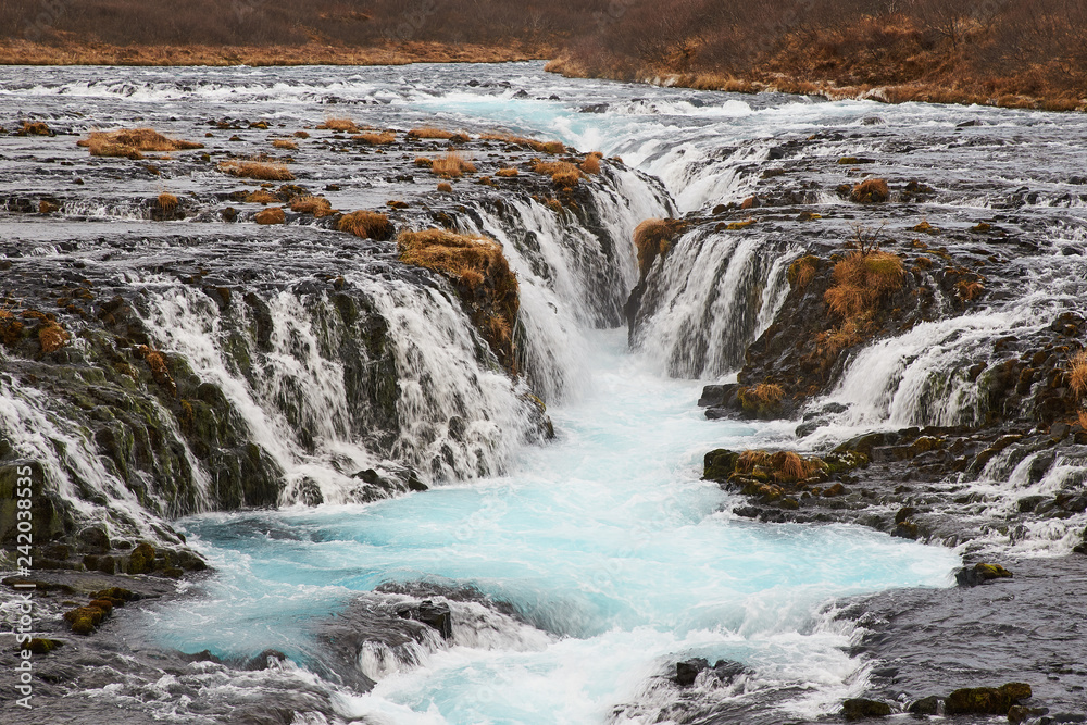 Bruarfoss (Bridge Fall), is a waterfall on the river Bruara, in southern Iceland where a series of small runlets of water runs into a beautiful, turquoise-blue colored pool. Bruarfoss (Bridge Fall), is a waterfall on the river Bruara, in southern Iceland where a series of small runlets of water runs into a beautiful, turquoise-blue colored pool.