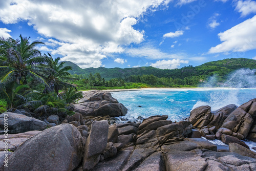 water fountain over granite rocks,wild tropical beach with palms, seychelles 4