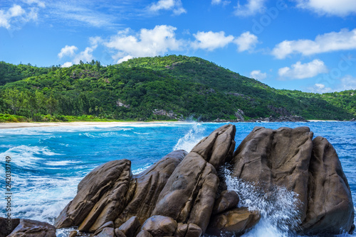 water fountain over granite rocks,wild tropical beach with palms, seychelles 9