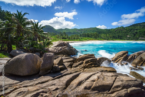 water fountain over granite rocks,wild tropical beach with palms, seychelles 33