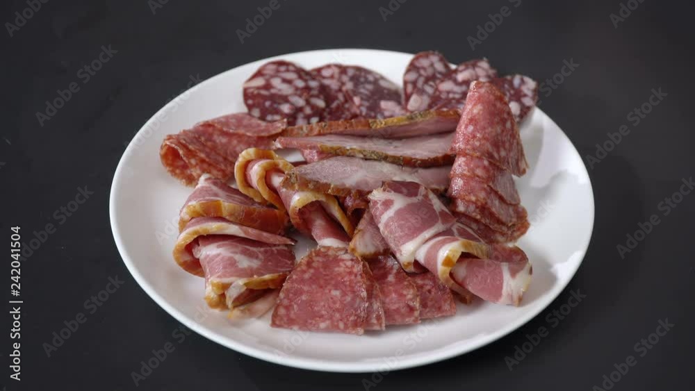 Cook puts smoked sausage on a plate