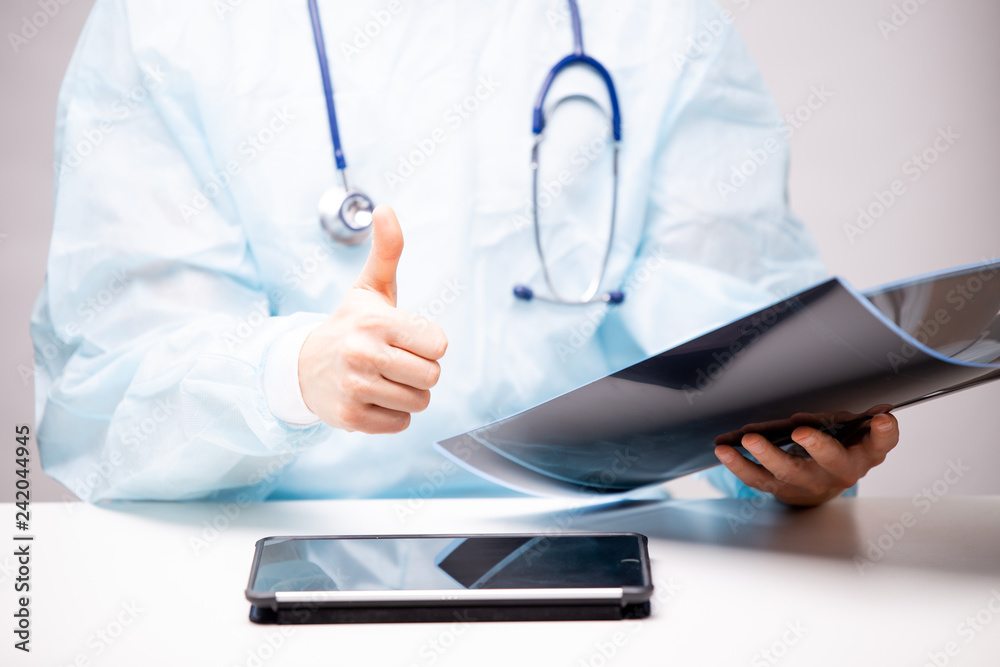 It is worth a doctor examines the x-ray and shows a thumb up It is worth a doctor examines the x-ray and shows a thumb up