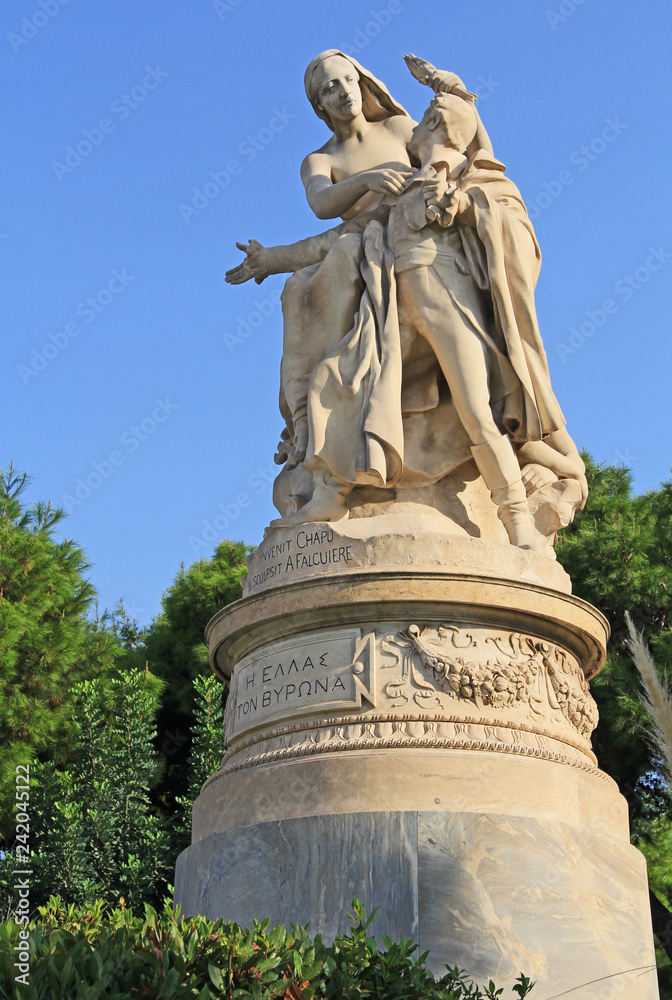 Public XIX century sculpture of the famous British poet Lord Byron crowned by personification of Greece in the National Garden in Athens, Greece with blue sky copy space.