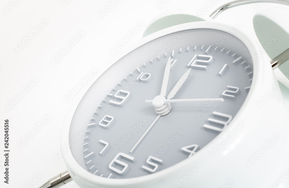 Twin bells analogue alarm clock shows time 5 to 12 with gray clock face, 11.55 AM PM, on white background Twin bells analogue alarm clock shows time 5 to 12 with gray clock face, 11.55 AM PM, on white background