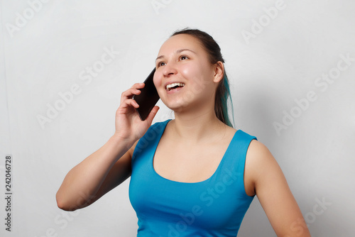Woman talk to phone. On grey background