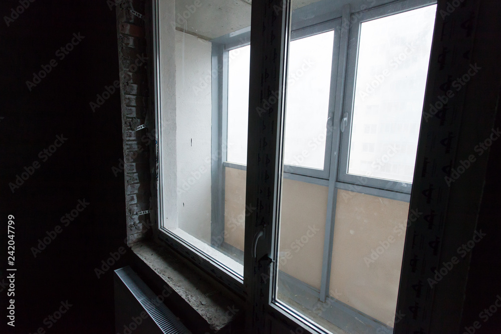 Unfinished building interior, gray room. Repairs in the apartment. Preparing in the room. Unfinished building interior, gray room. Repairs in the apartment. Preparing in the room.