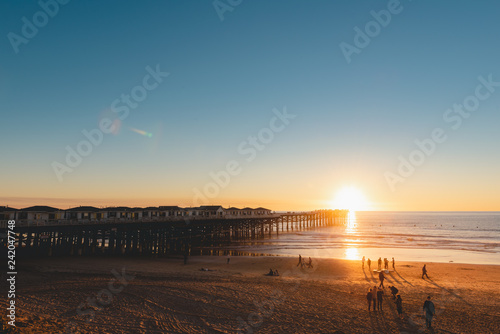 People doing activities at the beach near the pier with beautiful sunset. Pacific Beach in San Diego, California