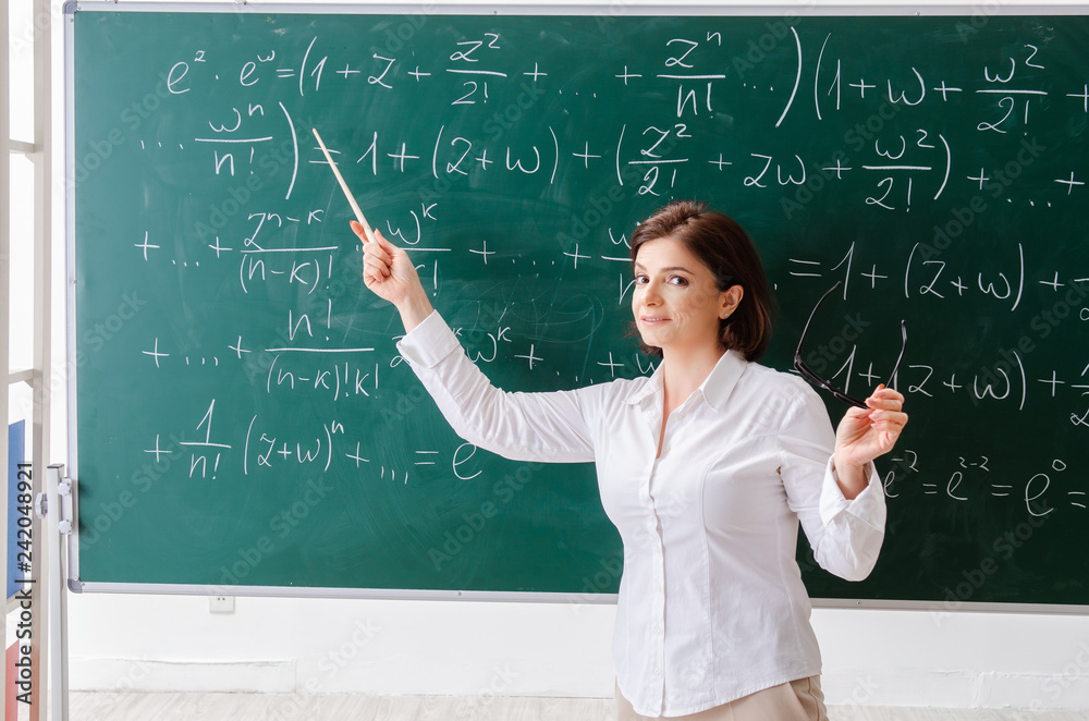 Female math teacher in front of the chalkboard Female math teacher in front of the chalkboard
